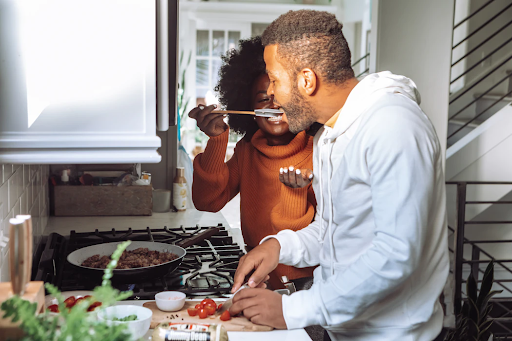 Couple chopping and sampling a recipe