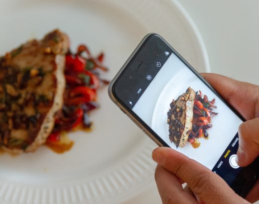 Close up of an iPhone taking a photo of a plate of food